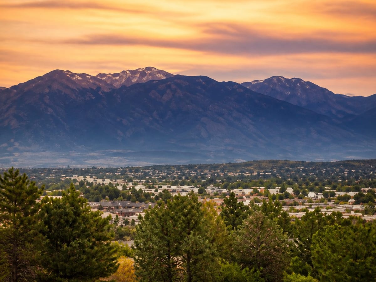 Front Range mountains above a tree-lined town at sunset